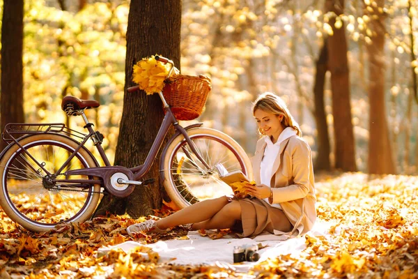Красивая Молодая Женщина Сидит Опавших Осенних Листьях Парке Читает Книгу — стоковое фото