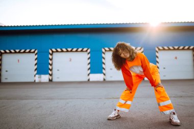 Afrika kökenli Amerikalı bir kız. Gün batımında sokakta dans ediyor. Spor, dans ve şehir kültürü konsepti. Moda yaşam tarzı.