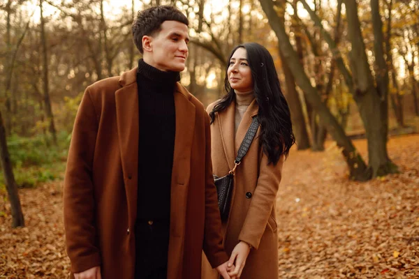 一对年轻夫妇在秋天的一天在公园散步 一起享受时光 在秋天的森林里 这对年轻貌美 充满爱心的夫妇彼此欣赏着 — 图库照片