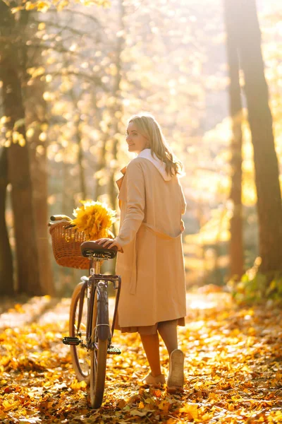 公園で秋の天気を楽しむ自転車とスタイリッシュな女性 秋の森を歩く美しい女 — ストック写真