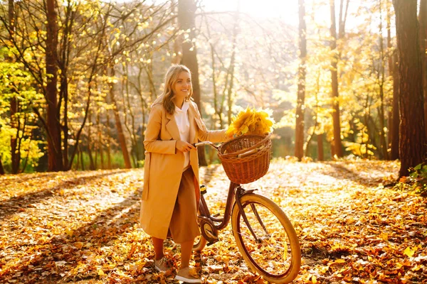 公園で秋の天気を楽しむ自転車とスタイリッシュな女性 秋の森を歩く美しい女 — ストック写真