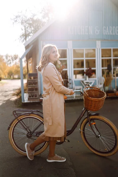 Bisikletli Şık Bir Kadın Mavi Bir Evin Arka Planında Sonbahar — Stok fotoğraf