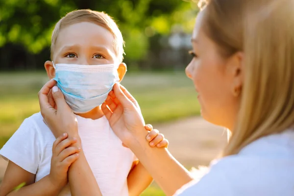 Mother Puts Her Baby Sterile Medical Mask Quarantine City Sunset — Stock Photo, Image