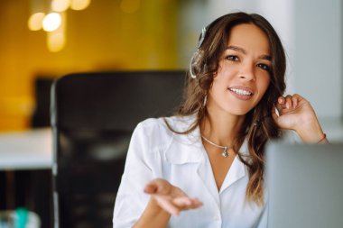 Telsizle çağrı merkezinde çalışan operatör kadın ajanın portresi. Genç bir kadın müşteri hizmetleri çalışanı olarak yardım ediyor. Danışmanlık ve yardım servisi çağrı merkezi.