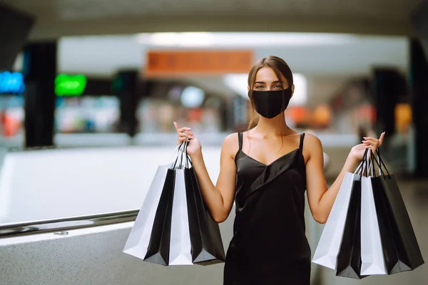 Egy Fiatal Védő Fekete Orvosi Maszkban Arcán Bevásárlószatyrokkal Plázában Vásárlások — Stock Fotó