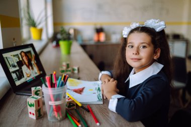 Bilgisayarlı liseli kız öğretmenle görüntülü konuşma yapıyor. Karantina ve koronavirüs salgını sırasında evde eğitim. Covid 2019.