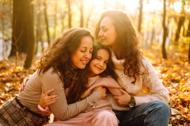 Güzel bir çift lezbiyen kız evlatlık kızlarıyla sonbahar ormanında eğleniyor. Genç homoseksüel aile kızıyla oynuyor.. 