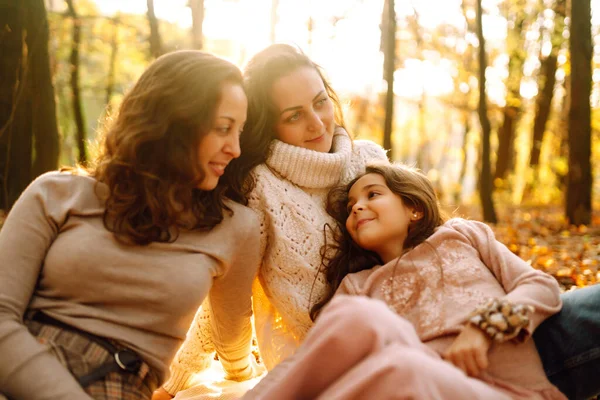 Güzel bir çift lezbiyen kız evlatlık kızlarıyla sonbahar ormanında eğleniyor. Genç homoseksüel aile kızıyla oynuyor.. 