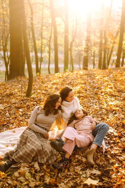 Güzel bir çift lezbiyen kız evlatlık kızlarıyla sonbahar ormanında eğleniyor. Genç homoseksüel aile kızıyla oynuyor.. 
