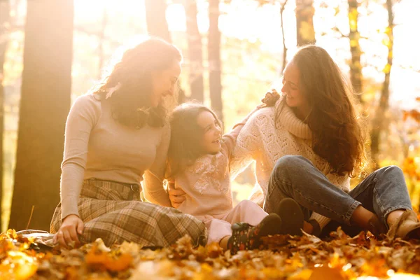 Güzel bir çift lezbiyen kız evlatlık kızlarıyla sonbahar ormanında eğleniyor. Genç homoseksüel aile kızıyla oynuyor.. 