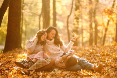 Güz ormanlarında retro kamerayla eğlenen güzel bir çift lezbiyen kadın. Genç homoseksüel aile ve evlatlık genç kızları fotoğraf için poz veriyorlar..