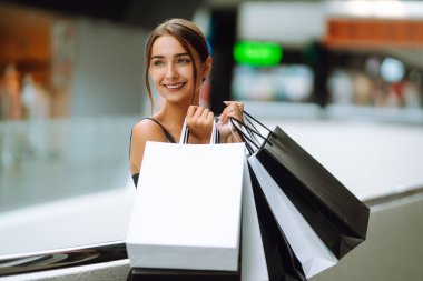 Alışveriş merkezinden alışveriş yapan siyah elbiseli moda kadını. Kara Cuma, satış, tüketim, yaşam tarzı konsepti.