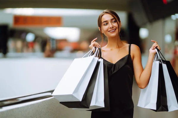 ショッピングバッグがショッピングモールで買い物を楽しむと黒のドレスのファッション女性 黒の金曜日 消費主義 ライフスタイルの概念 — ストック写真