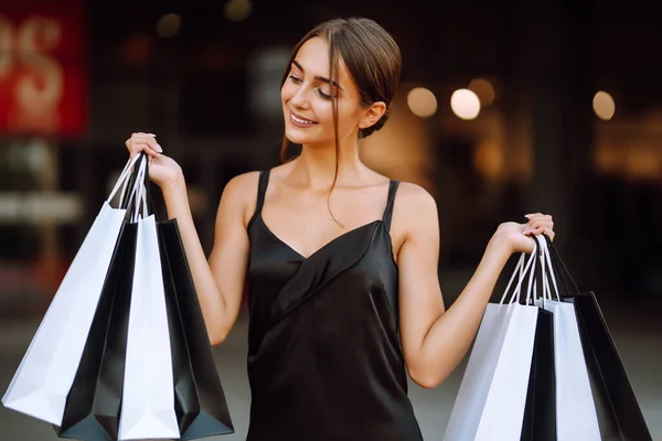 Mujer Moda Disfrutando Compras Mujer Elegante Lleva Vestido Negro Sosteniendo —  Fotos de Stock