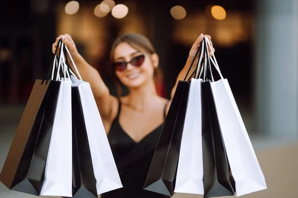 购物袋在手里 购物后带着包裹的时尚女人 黑色星期五 消费主义 生活方式概念 — 图库照片