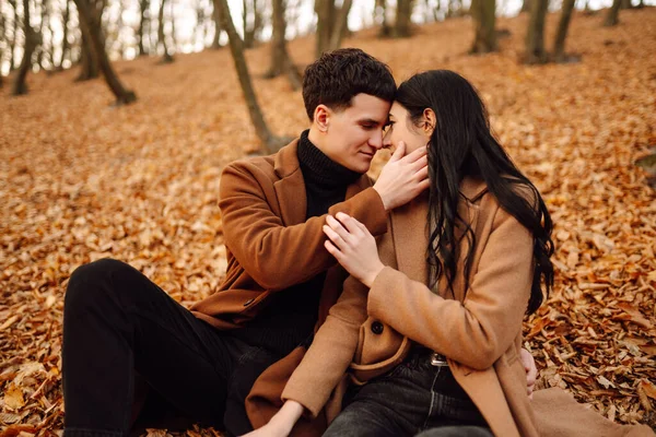 Lovely couple having fun together in the autumn forest. Fashion couple enjoying autumn weather. Fashion, lifestyle and autumn mood.