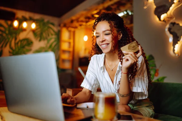 카드를 노트북 컴퓨터를 사용하는 아프리카계 미국인 여성이 인터넷 쇼핑을 카페에 — 스톡 사진