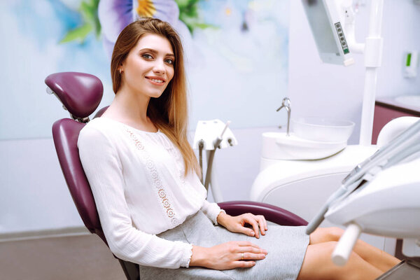 Beautiful woman patient at the dentist's chair. Overview of dental caries prevention. Healthy Smile. 