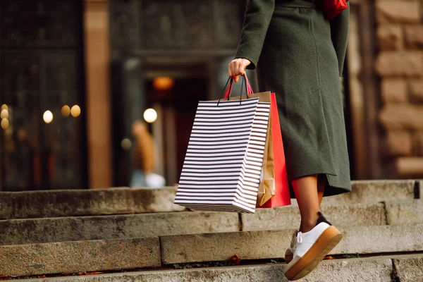 手にショッピングバッグ 通りを歩きながらプレゼントを購入した後の購入でマルチカラーのバッグを持つスタイリッシュな女性の手 消費主義 ブラックフライデーの概念 — ストック写真