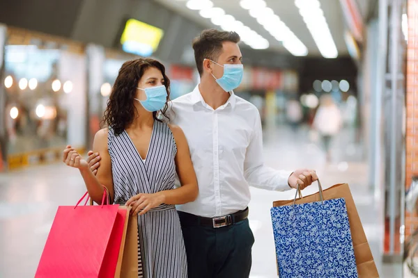ショッピングバッグを持っている幸せな美しい若いカップルは ショーケースを見て モールに立って笑顔 一緒に買い物を 消費主義 ブラックフライデーの概念 — ストック写真