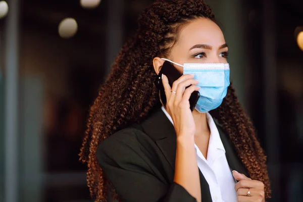 Młoda Biznesmenka Masce Ochronnej Rozmawiająca Przez Telefon Podczas Pandemii Koronawirusa — Zdjęcie stockowe