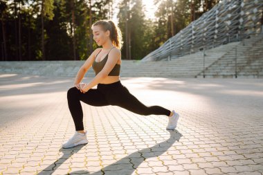 Spor kıyafetli bir kadın dışarıda egzersiz yapıyor. Sunny Park 'ta spor yapan aktif bir kadın. Spor, etkinlik ve sağlık konsepti.