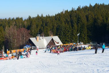 İnsanlar kar kaplı dağlarda kayak asansöründen aşağı inerler.
