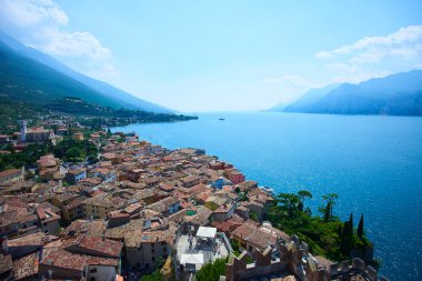 beautiful view, blue lake water in mountains and small town buildings 