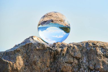 transparent glass ball, sphere on stone  