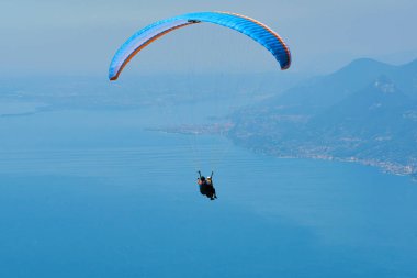 Mavi gökyüzü ve paraşütçü gökyüzünde paraşütle atlıyor 