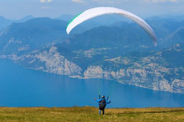 Dağlardaki yeşil çayır ve paraşütçü paraşütçü 