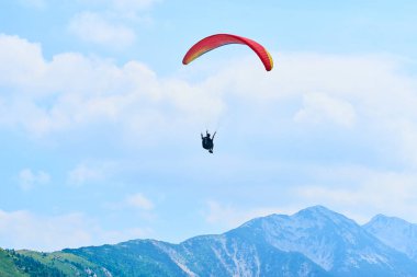 Mavi gökyüzü ve paraşütçü gökyüzünde paraşütle atlıyor 