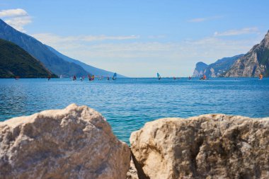 beautiful view, mountain hills and blue lake, people windsurfing 