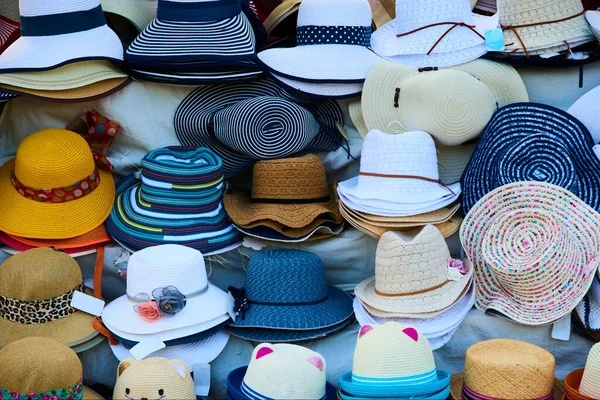 straw and summer season hats on the shelves in market 