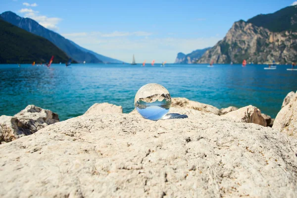glass sphere levitating at blue water