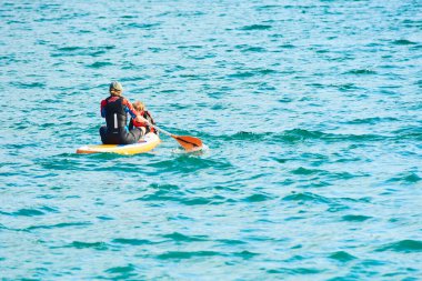 İnsanlar sup 'ta yüzüyor, mavi su 