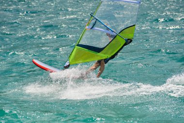 sailing and surfing man in sea water, windsurfing sport activity at summer 