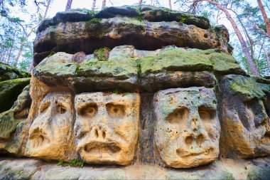 Bizarre Stone Heads, rock sculptures of giant heads carved in sandstone cliffs, village Zelizy, Melnik, Czech republic 