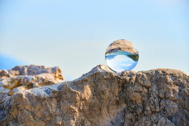 transparent glass ball, sphere on stone  