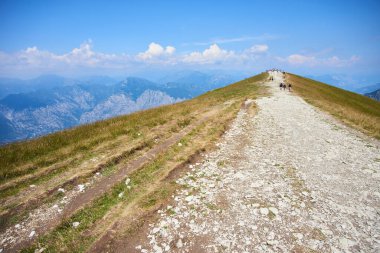 group of people hiking in mountains hills sky with clouds 