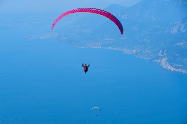 Mavi gökyüzü ve paraşütçü gökyüzünde paraşütle atlıyor 