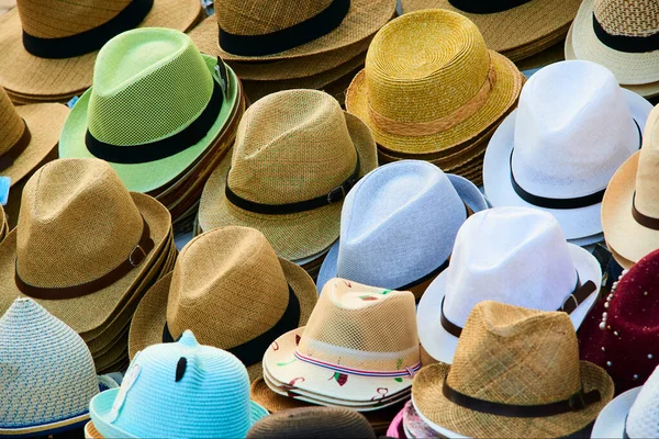 straw and summer season hats on the shelves in market