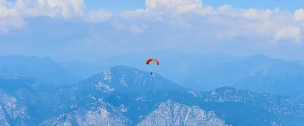 parachutist skydiving in sky, action sport in mountains 