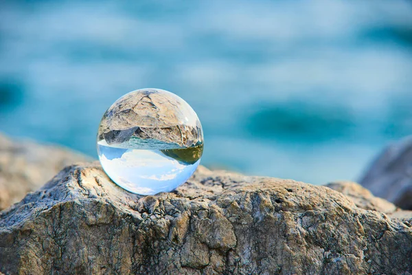 transparent glass ball, sphere on stone