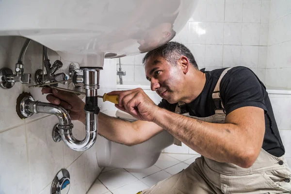 Especialista hombre plomero reparaciones grifo en el baño — Foto de Stock