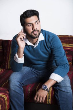 Gülümseyen adam akıllı telefon ile rahat oturuyor