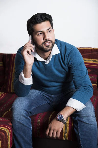 Gülümseyen adam akıllı telefon ile rahat oturuyor