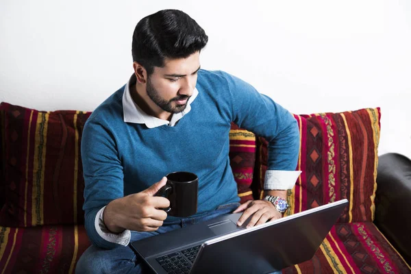 Man sitting in casual clothes working on computer.