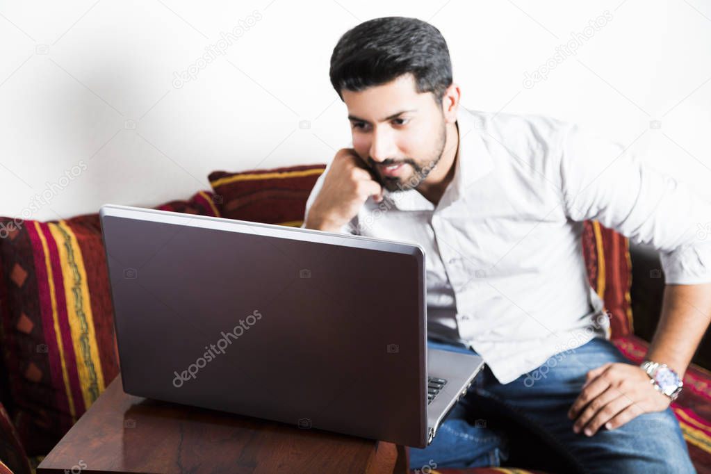 Man sitting in casual clothes working on computer.