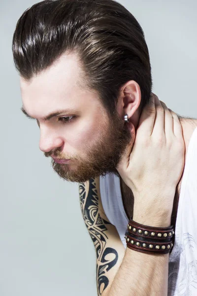 Жорстокий м'язистий сексуальний чорний волохатий незадоволений молодий чоловік з татуюванням на плечі і бороді — стокове фото